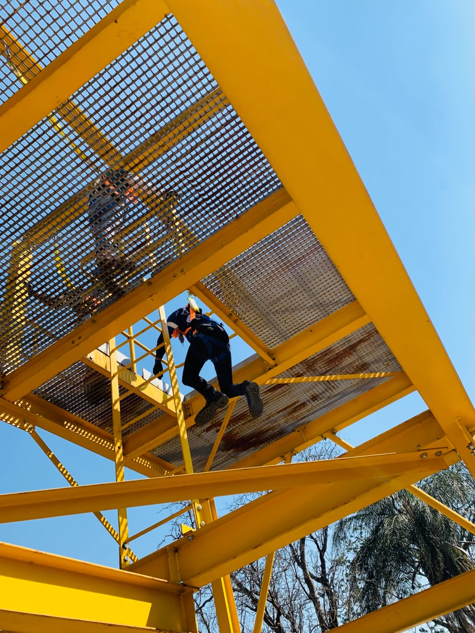 Overhead view of team member navigating structural steel at height